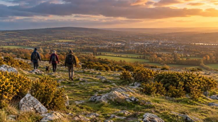 Walkers crossing a high open limestone common in autumn, with a wide view over the vale below