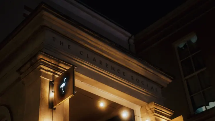 The lit stone entrance of The Clarence Social on Clarence Parade at night
