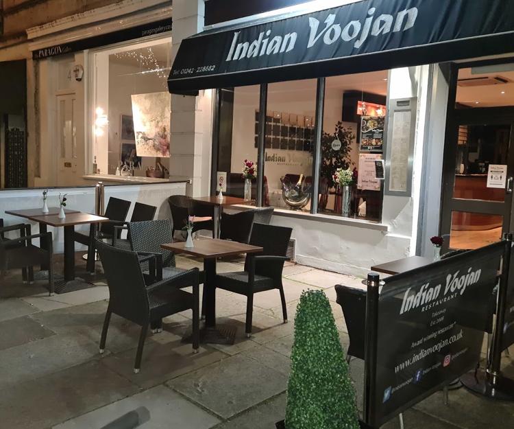 Outdoor tables and the Indian Voojan sign on Rotunda Terrace, Montpellier, Cheltenham