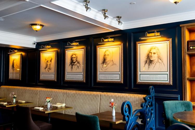 Framed portraits above a banquette at Memsahib's Lounge, Cheltenham